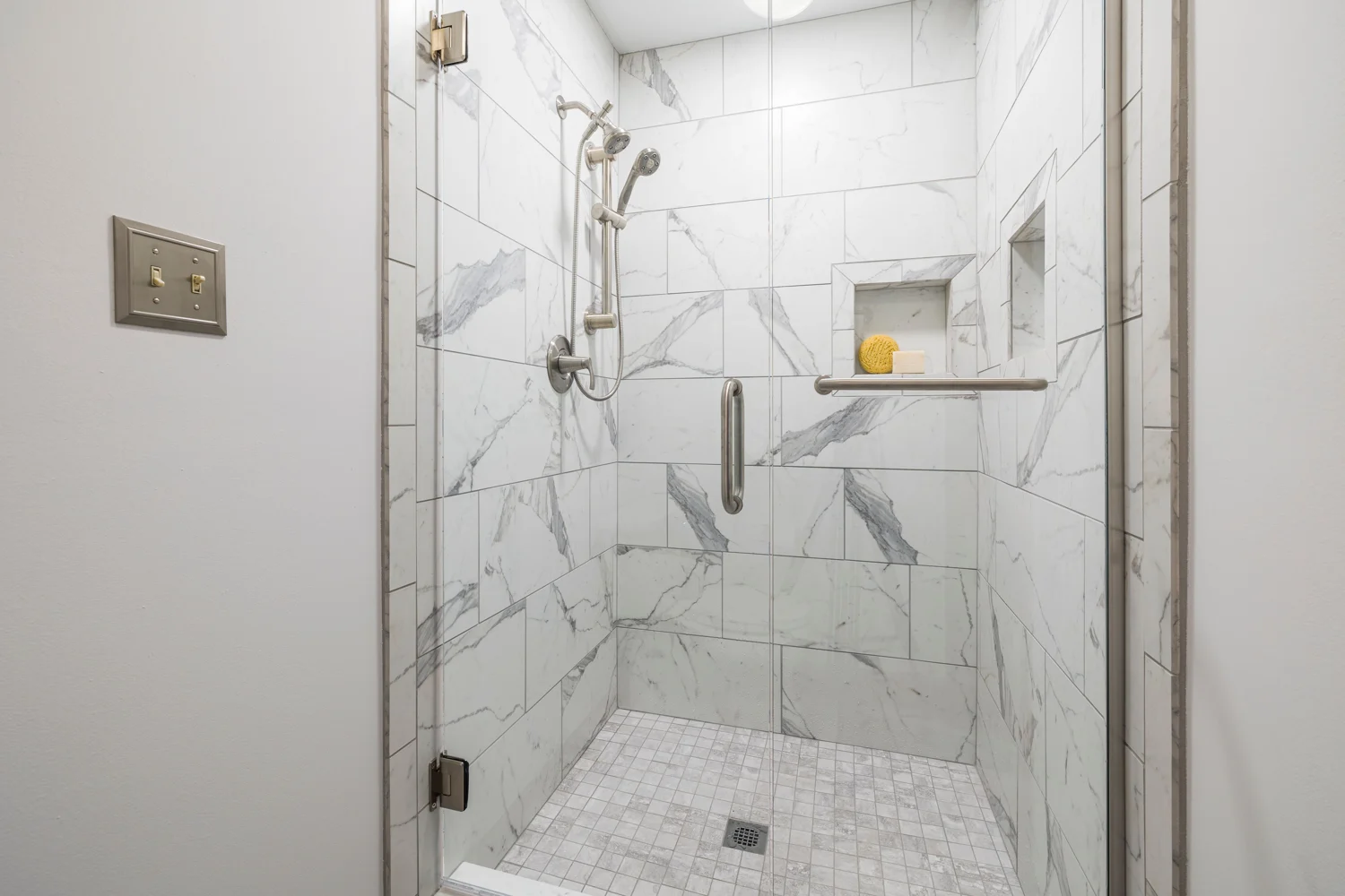Fertiges Badezimmer mit gefliester Dusche und Glasabtrennung